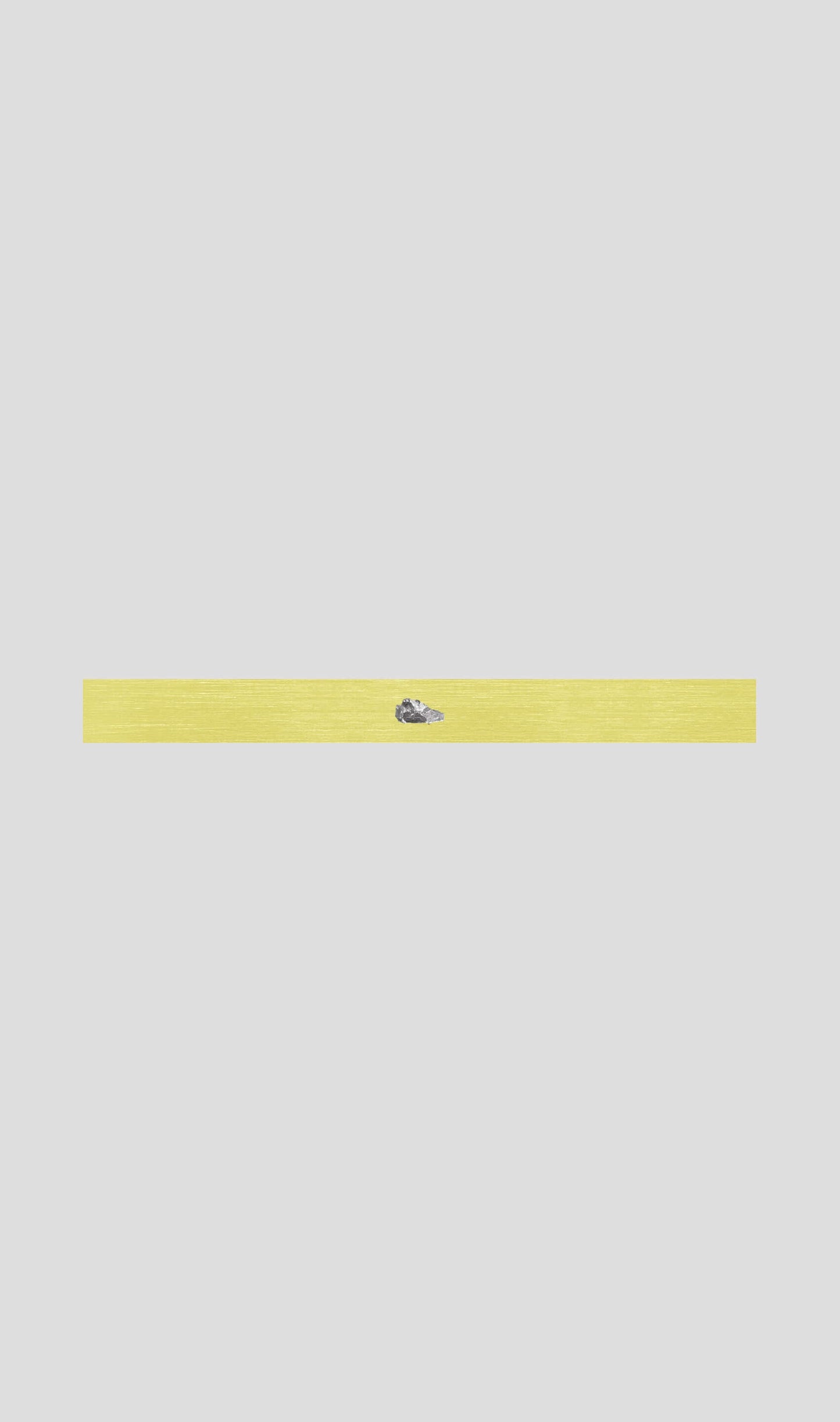 Streamlined yellow bracelet featuring a delicate design with a small blue accent, showcasing minimalistic elegance.