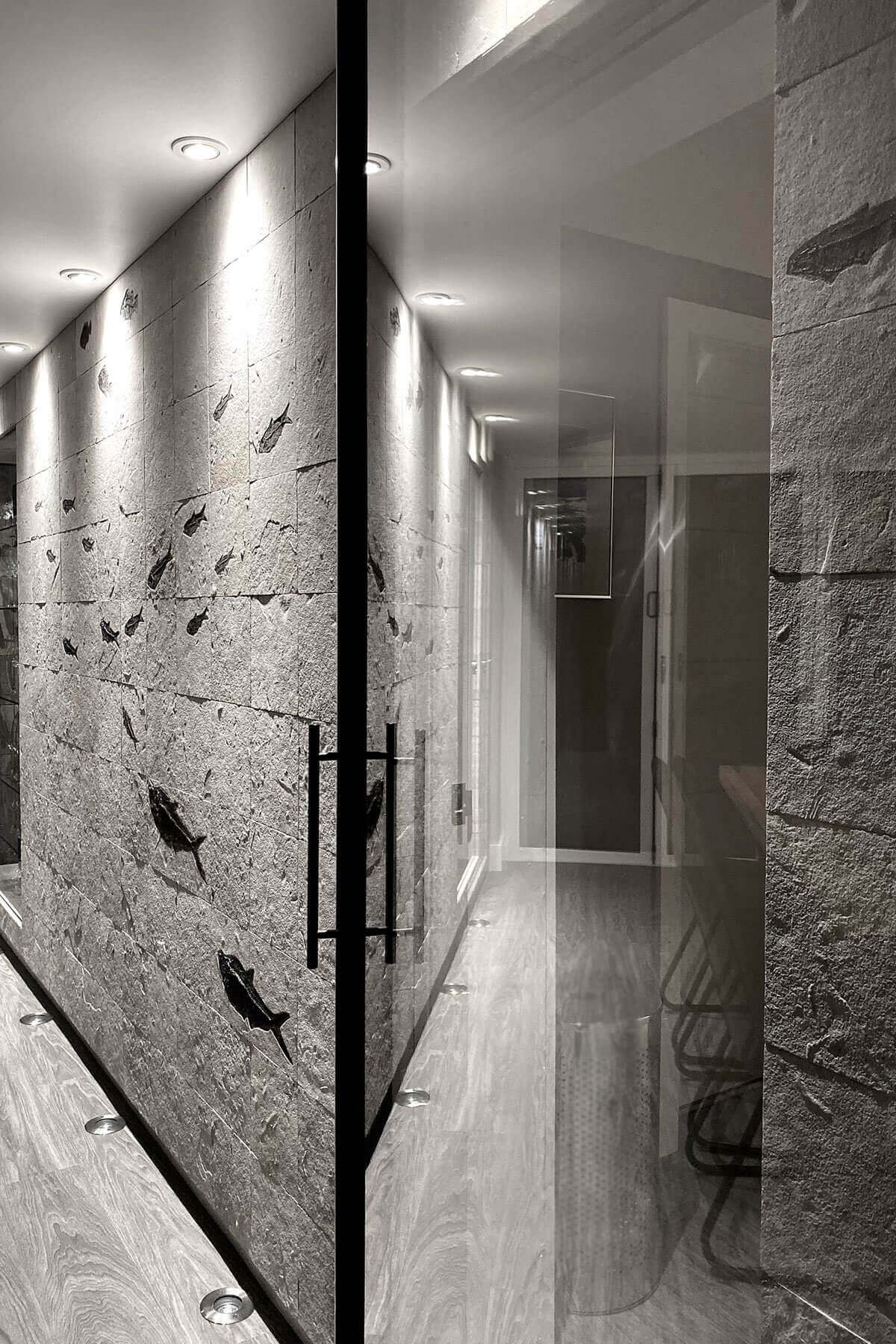 GARwall© Fossil Fish Tiled Gallery Feature Wall showcasing detailed fossil fish designs in a modern corridor setting.