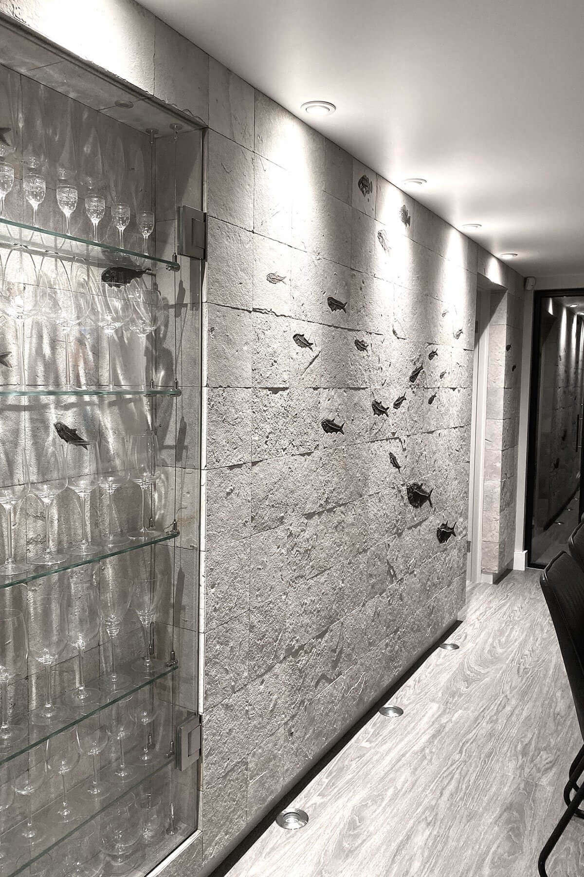 Serene GARwall© fossil fish tiled feature wall with intricate details and soft lighting.