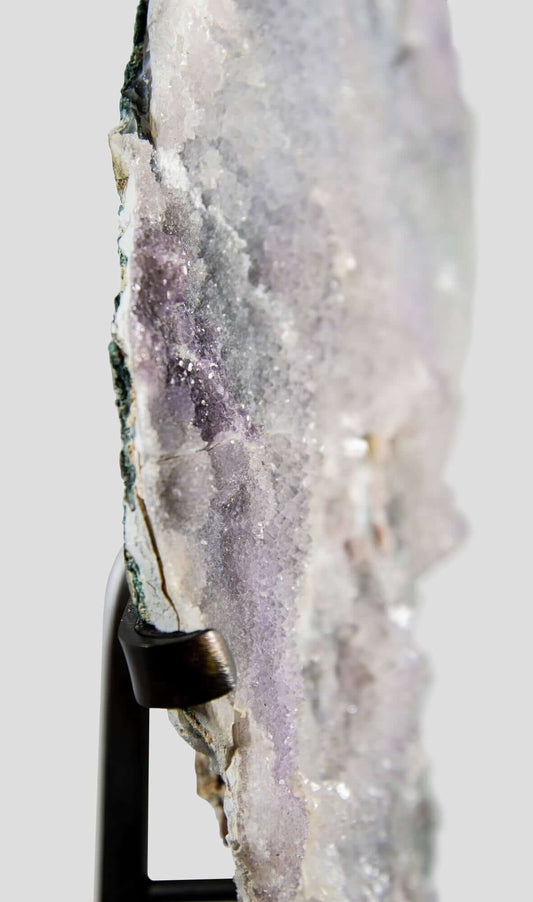 Shell amethyst presented on a lxury bronze stand contrasting the soft purple hues of the fine amethyst clusters within 12