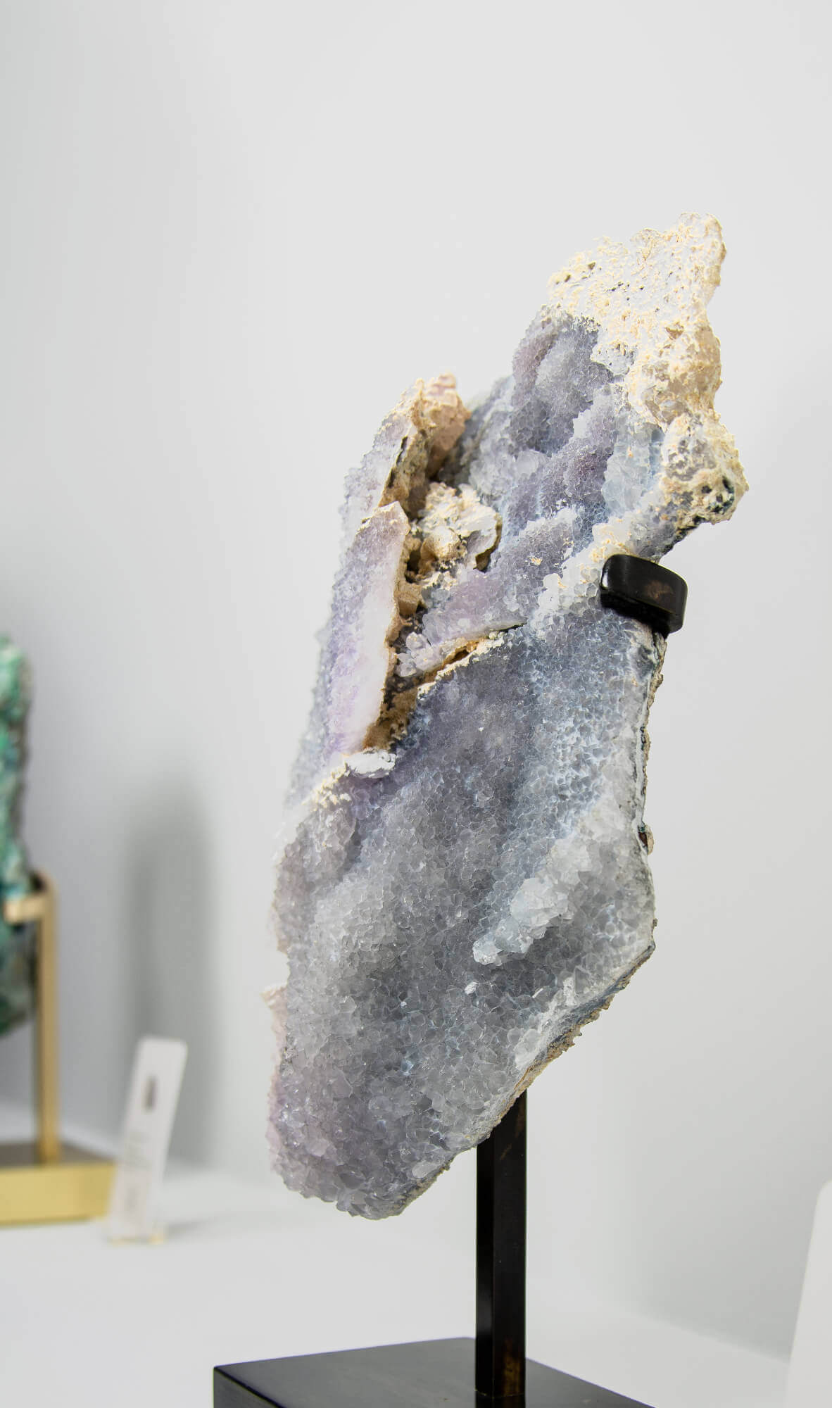 Shell amethyst presented on a lxury bronze stand contrasting the soft purple hues of the fine amethyst clusters within 4