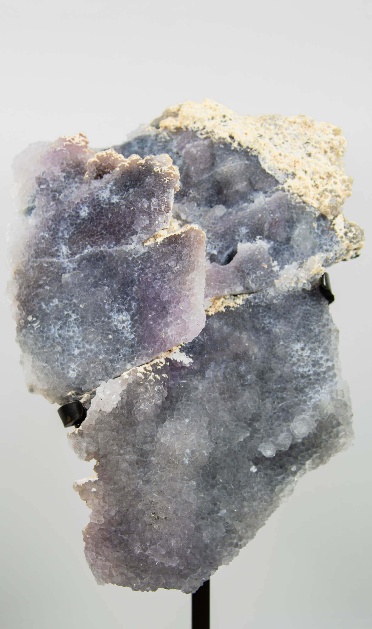 Shell amethyst presented on a lxury bronze stand contrasting the soft purple hues of the fine amethyst clusters within 5