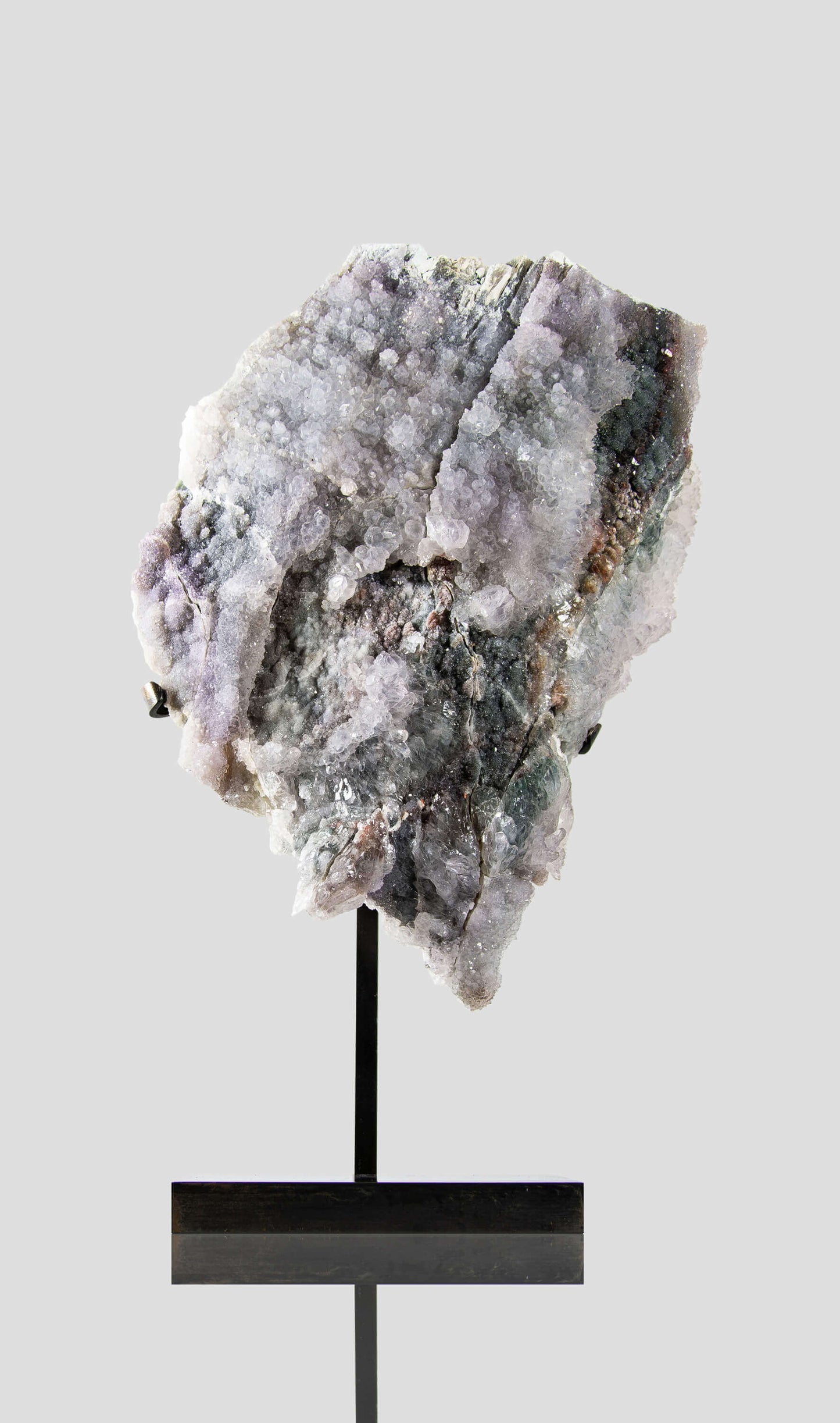 Shell amethyst presented on a lxury bronze stand contrasting the soft purple hues of the fine amethyst clusters within 11