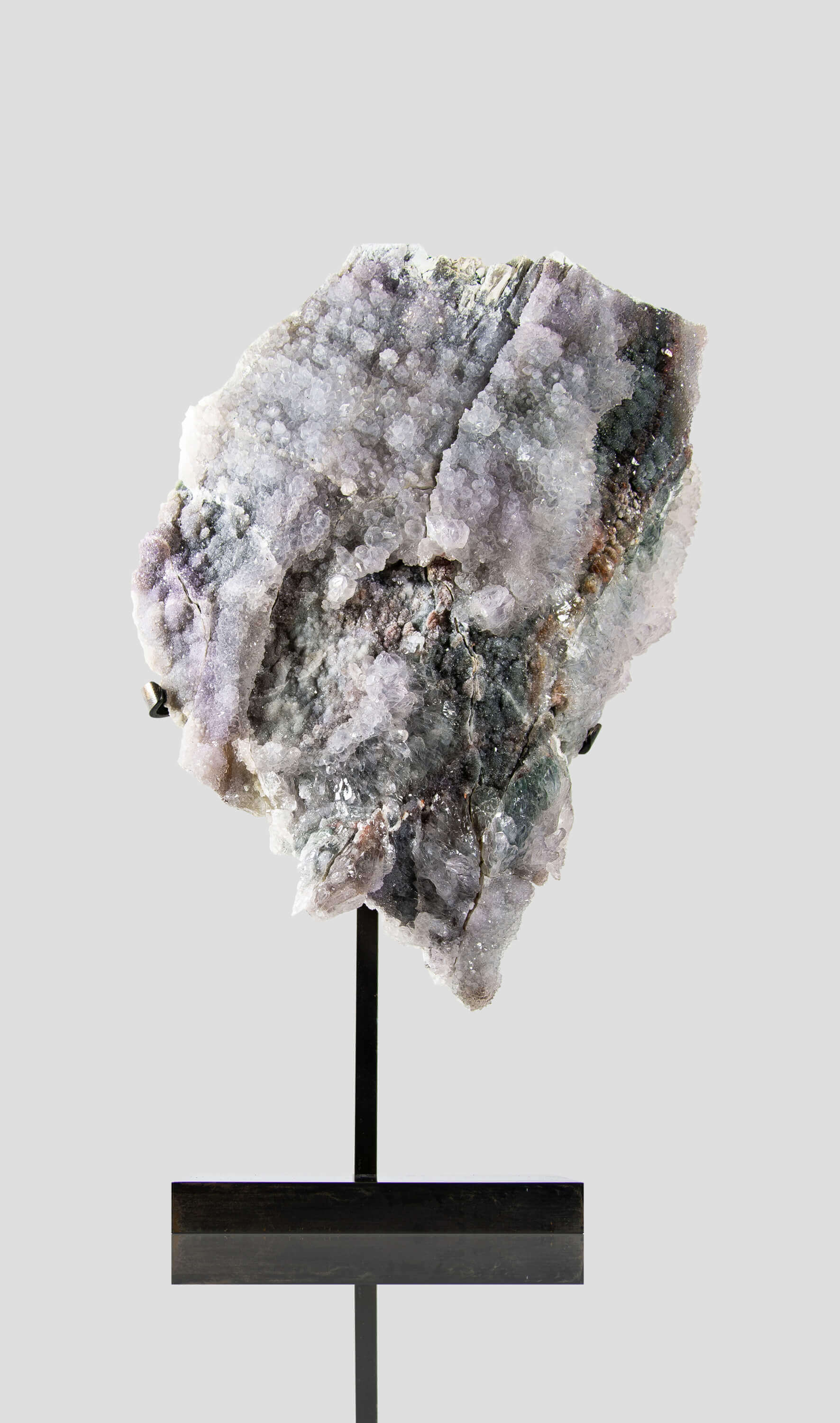 Shell amethyst presented on a lxury bronze stand contrasting the soft purple hues of the fine amethyst clusters within 11