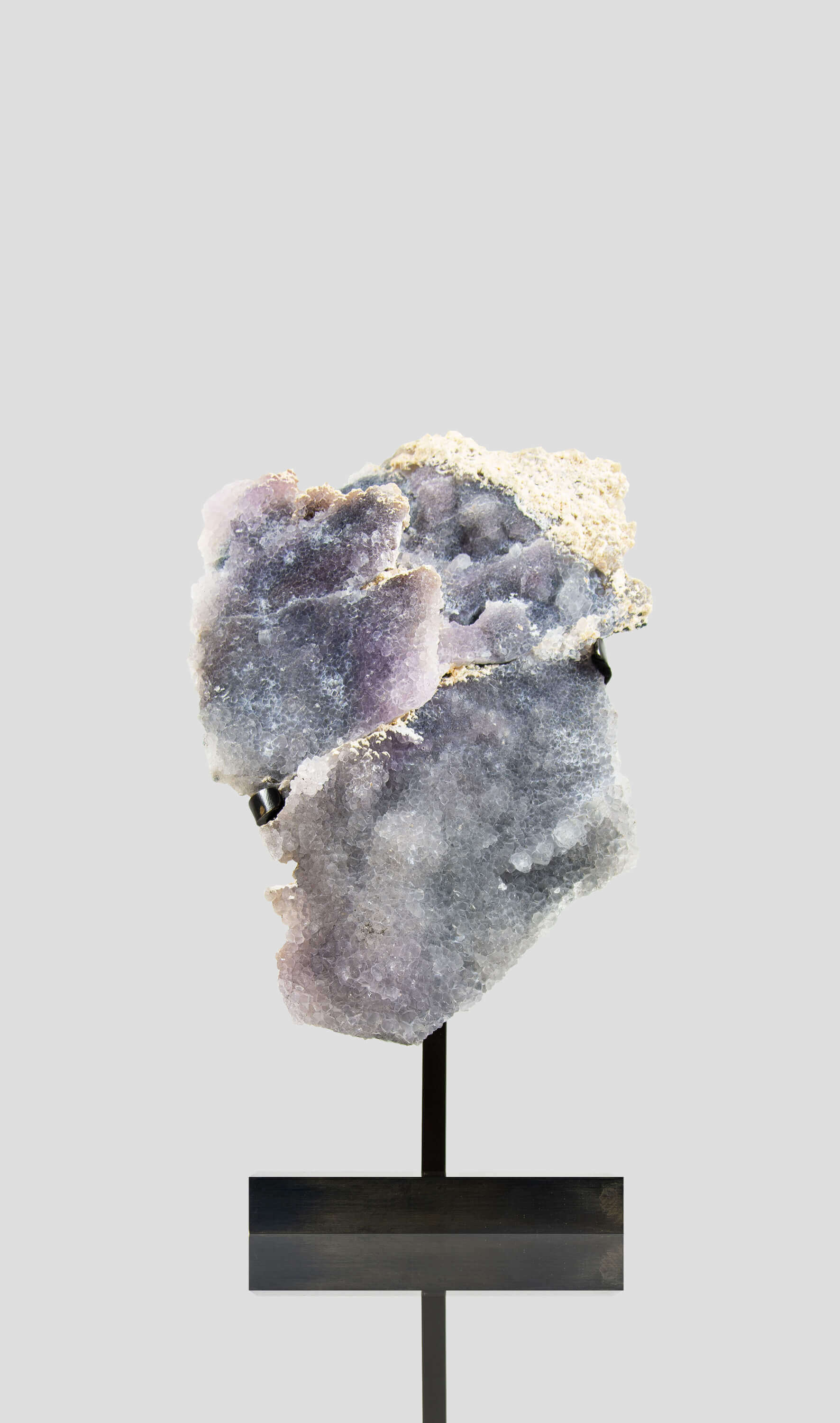 Shell amethyst presented on a lxury bronze stand contrasting the soft purple hues of the fine amethyst clusters within 1